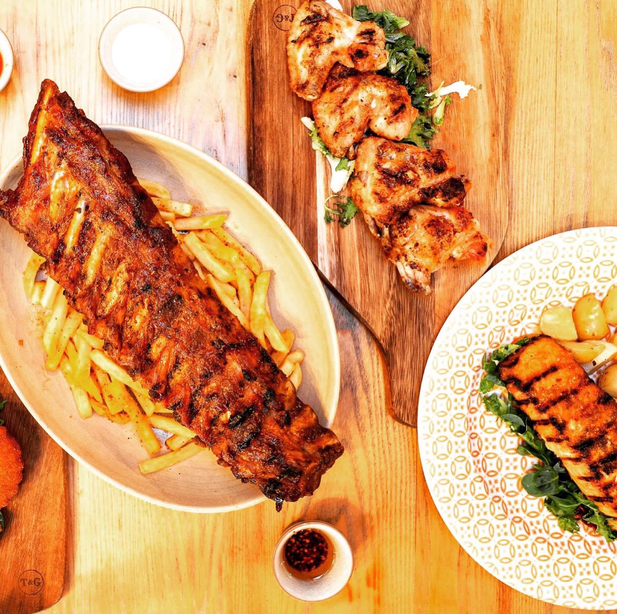 A sharing spread of ribs, grilled chicken and salmon at Diego's Rotisserie