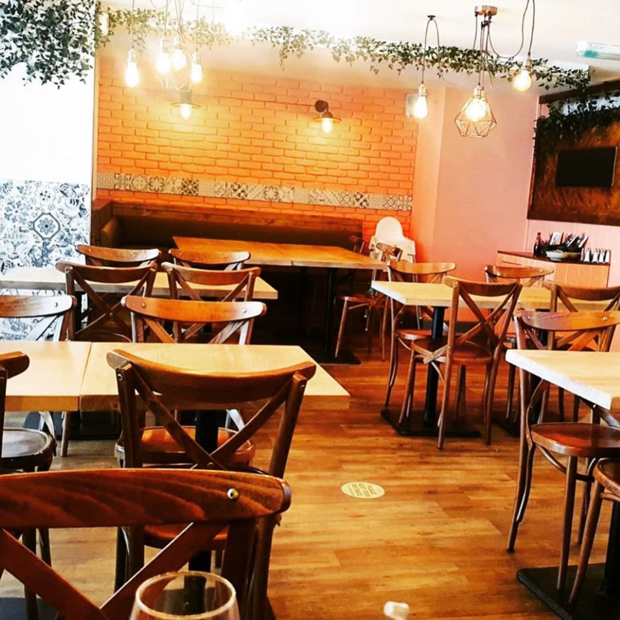 The main dining room at Diego's Rotisserie with azulejo tiles and wooden tables