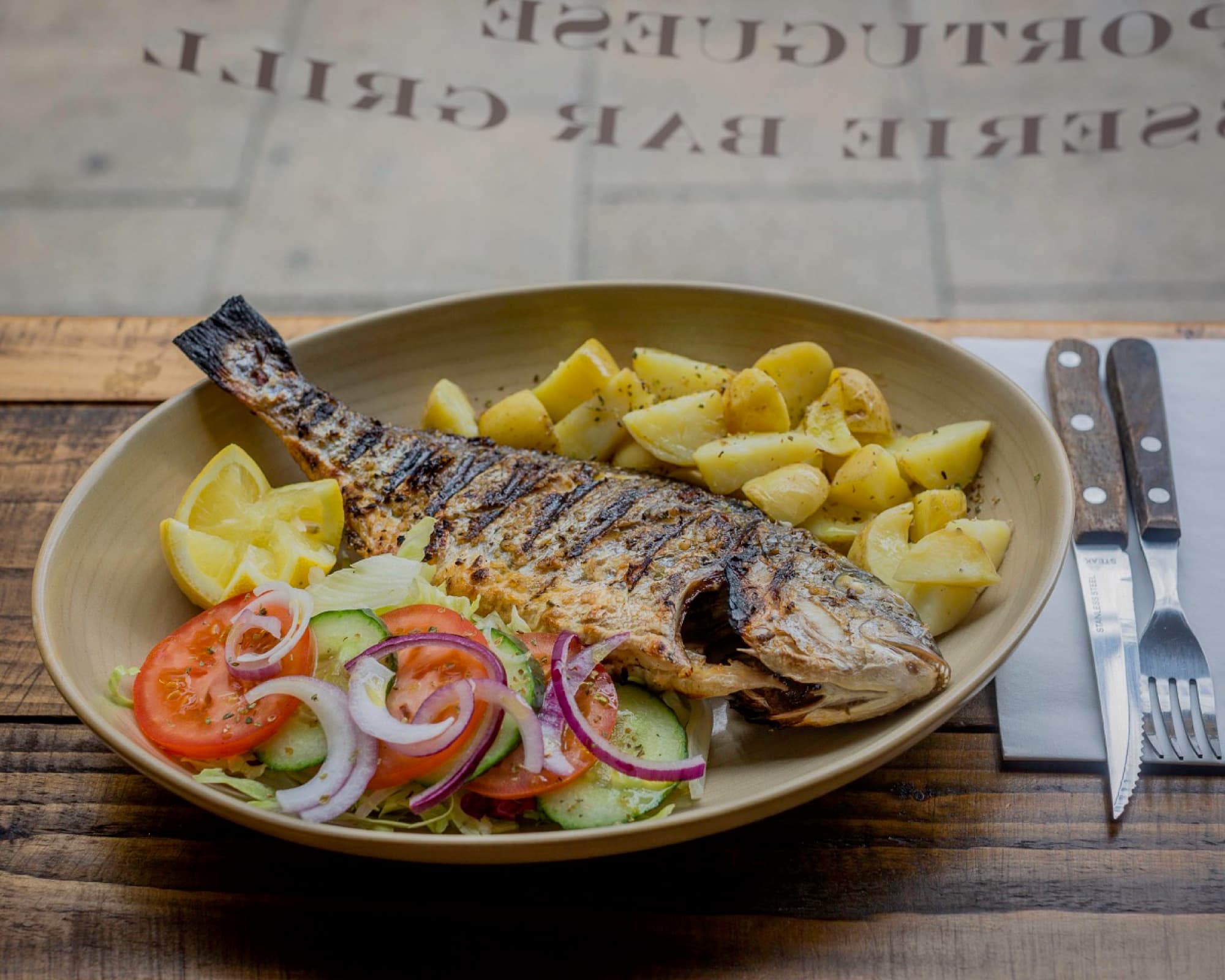 Whole grilled sea bream with potatoes and salad at Diego's